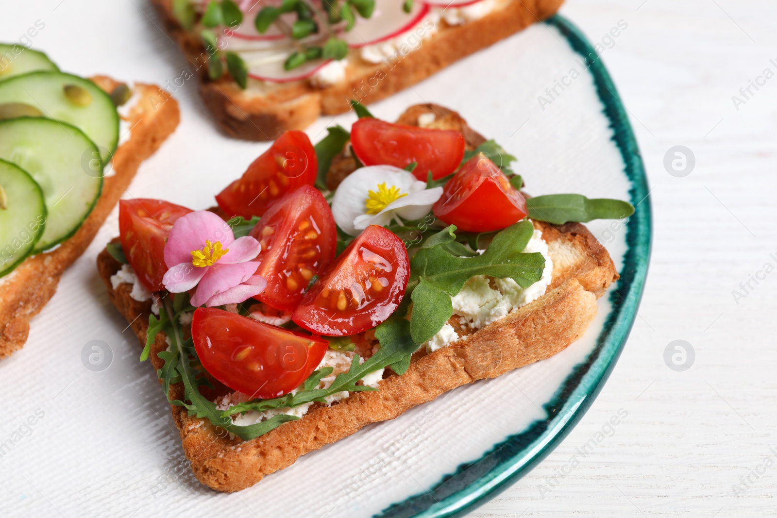 Photo of Different delicious sandwiches on white wooden table, closeup