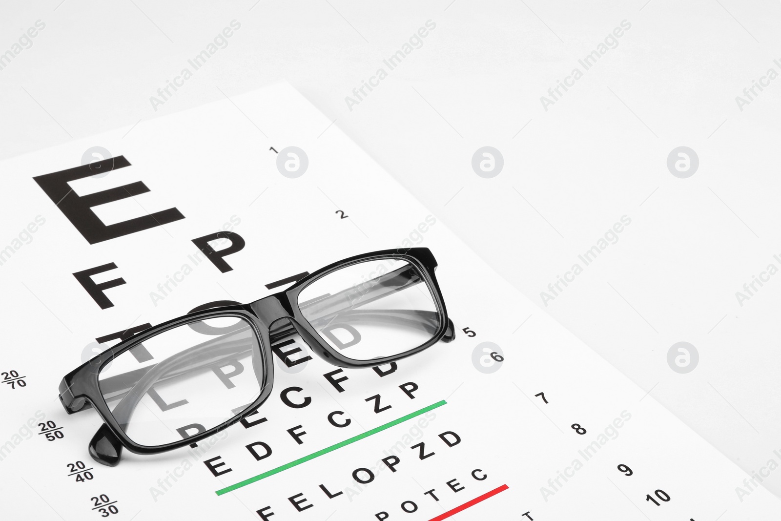 Photo of Glasses and vision test chart isolated on white