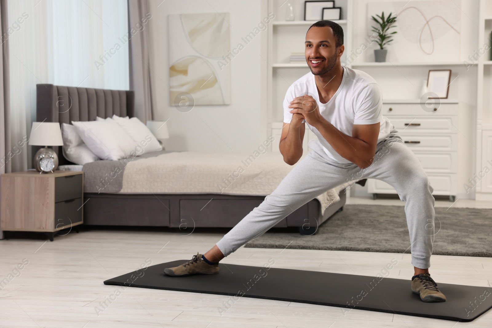 Photo of Man doing morning exercise on fitness mat at home