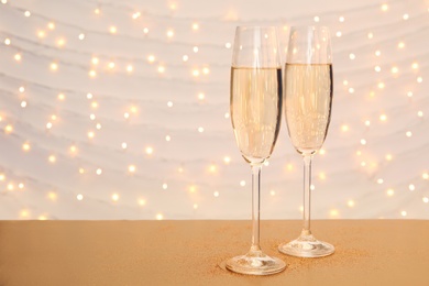 Glasses of champagne on table against blurred lights