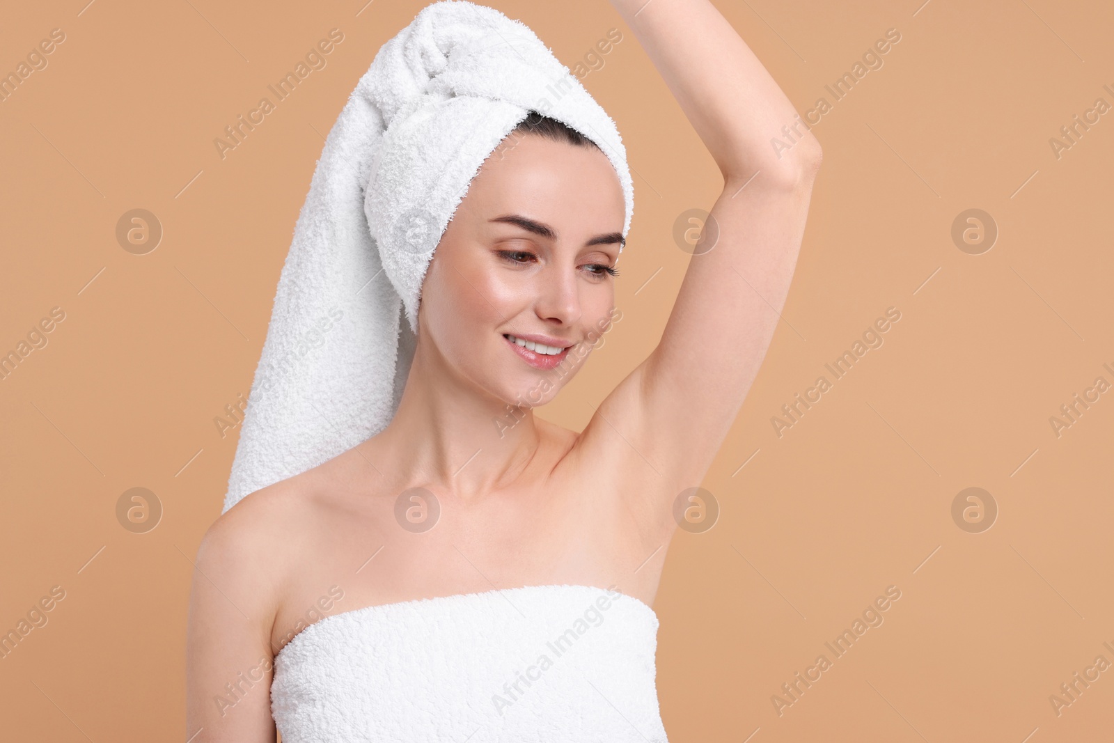 Photo of Beautiful woman showing armpit with smooth clean skin on beige background