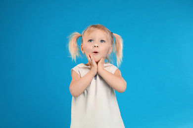 Photo of Cute little girl posing on light blue background
