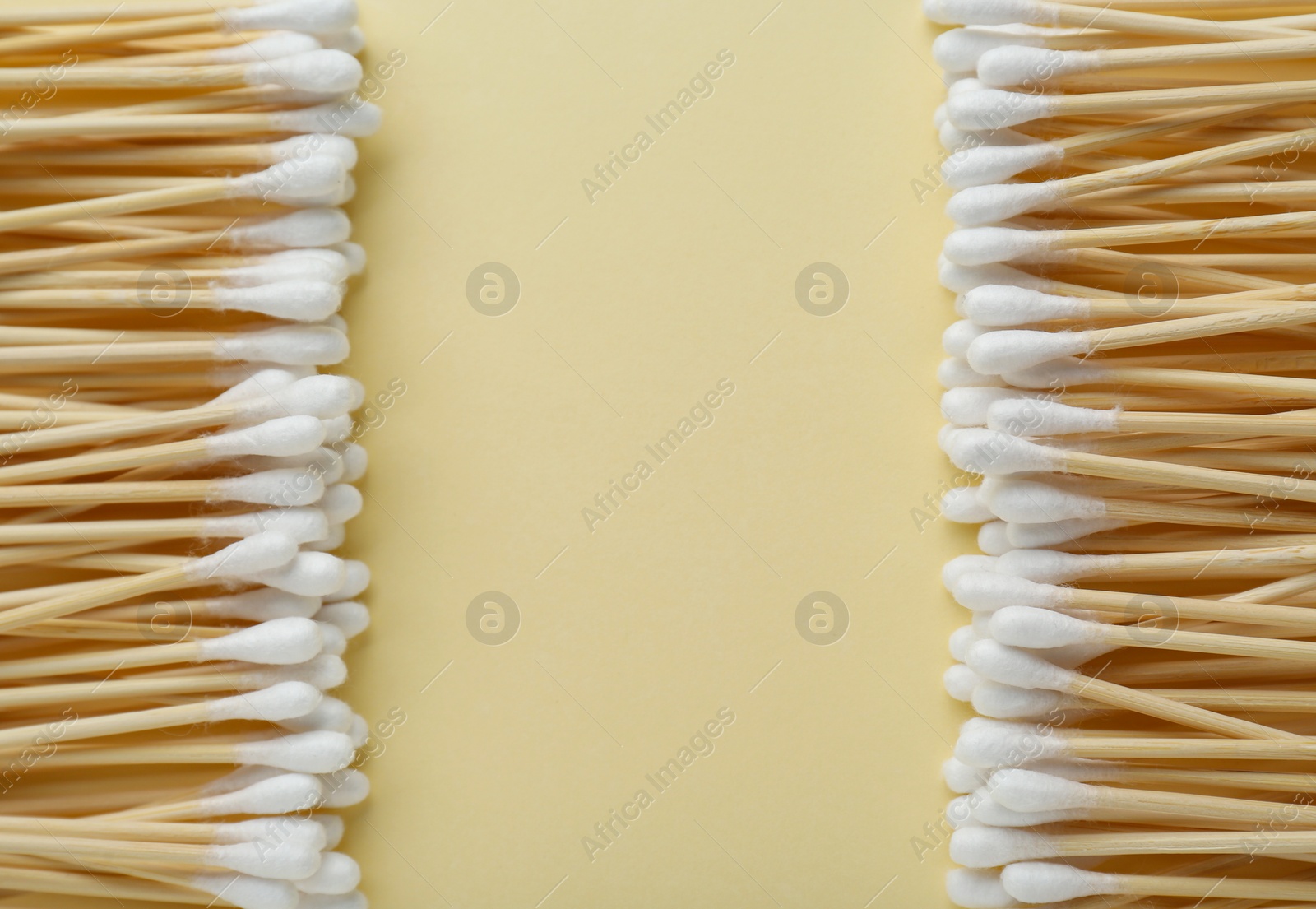 Photo of Many wooden cotton buds on beige background, flat lay. Space for text