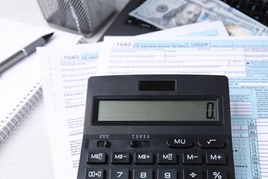 Tax accounting. Calculator, documents, money and stationery on light grey table, closeup