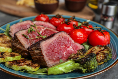 Photo of Delicious sliced beef steak with vegetables, closeup view