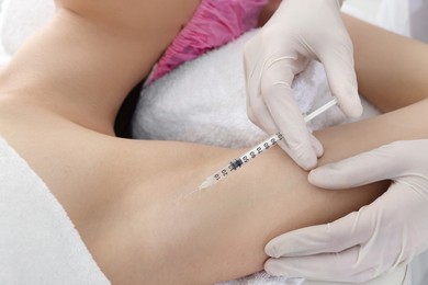 Photo of Cosmetologist injecting young woman's armpit, closeup. Treatment of hyperhidrosis