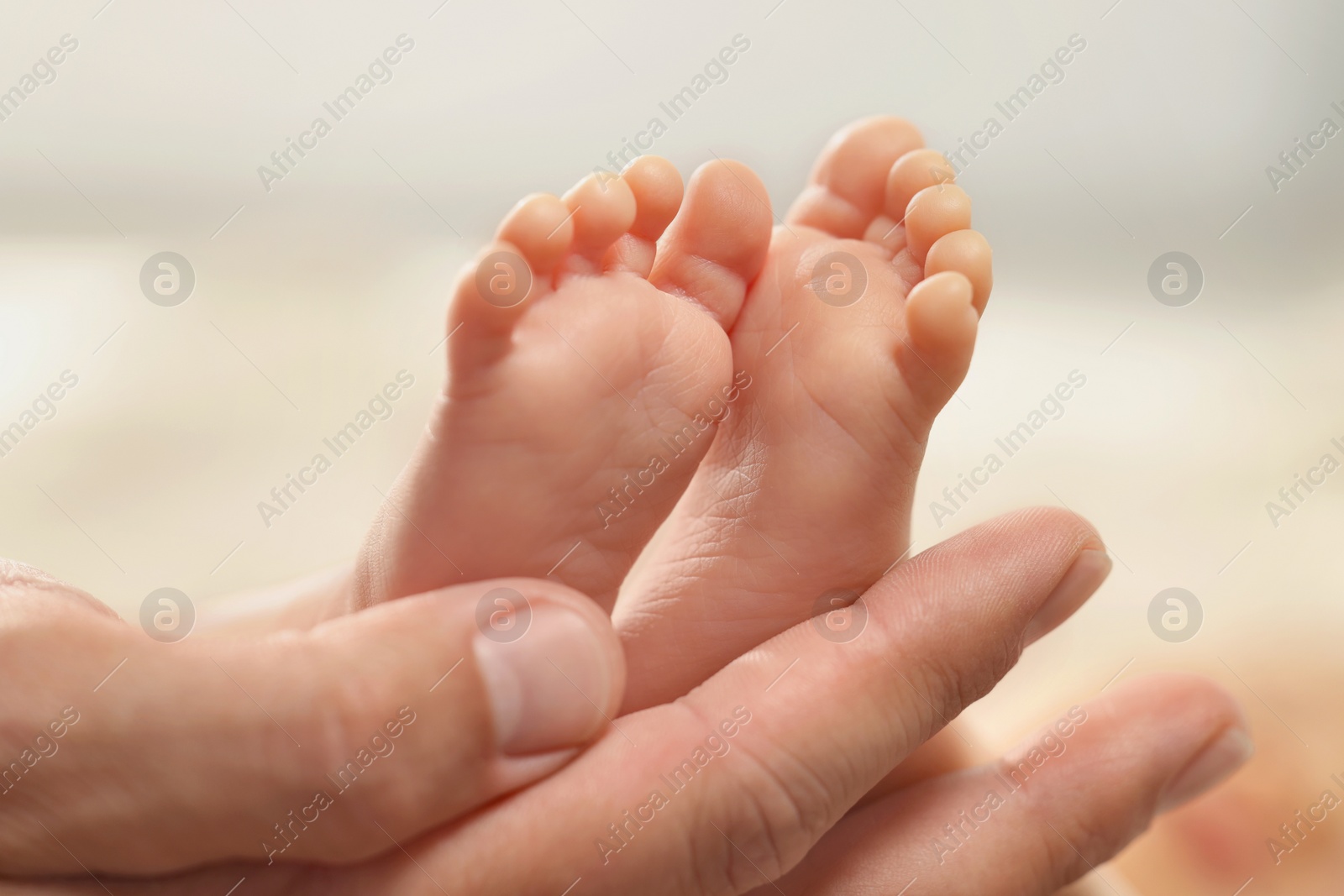Photo of Father holding his newborn baby, closeup view on feet. Lovely family