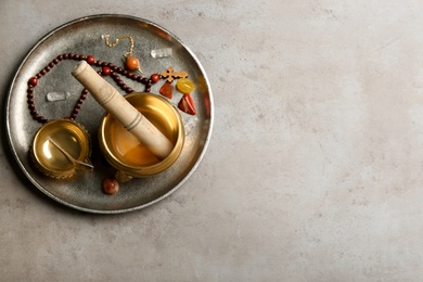 Composition with golden singing bowl on grey table, top view and space for text. Sound healing