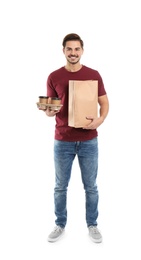 Young courier with paper bag and drinks on white background. Food delivery service