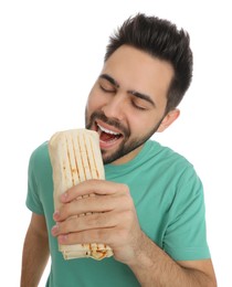 Young man eating tasty shawarma isolated on white