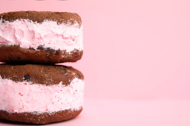 Photo of Sweet delicious ice cream cookie sandwiches on color background, closeup. Space for text