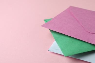 Colorful paper envelopes on pink background, closeup. Space for text