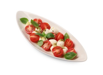 Photo of Plate of tasty Caprese salad with mozzarella, tomatoes, basil and pesto sauce isolated on white