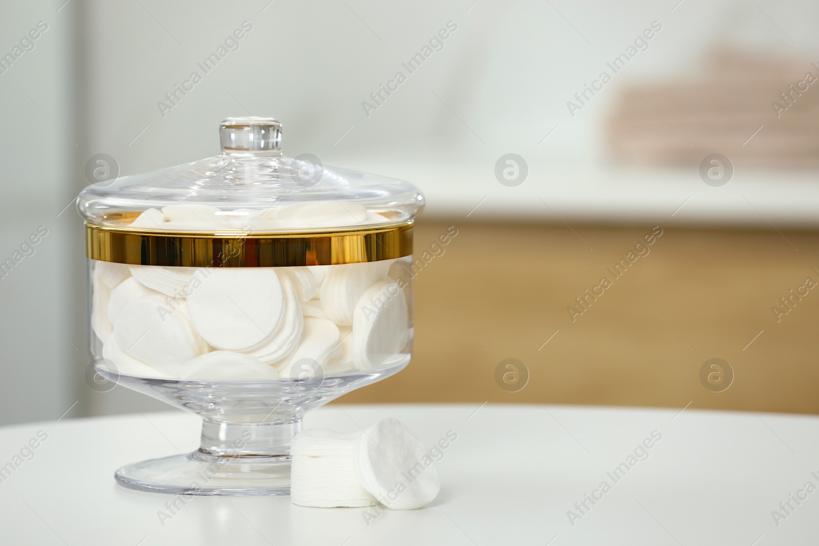 Photo of Composition of glass jar with cotton pads on table in bathroom. Space for text