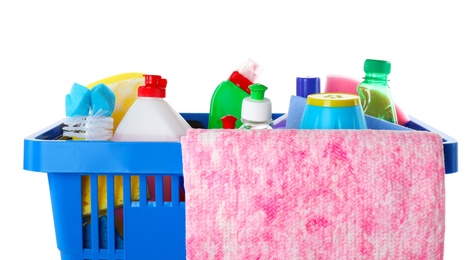 Photo of Shopping basket with different detergents and rag on white background