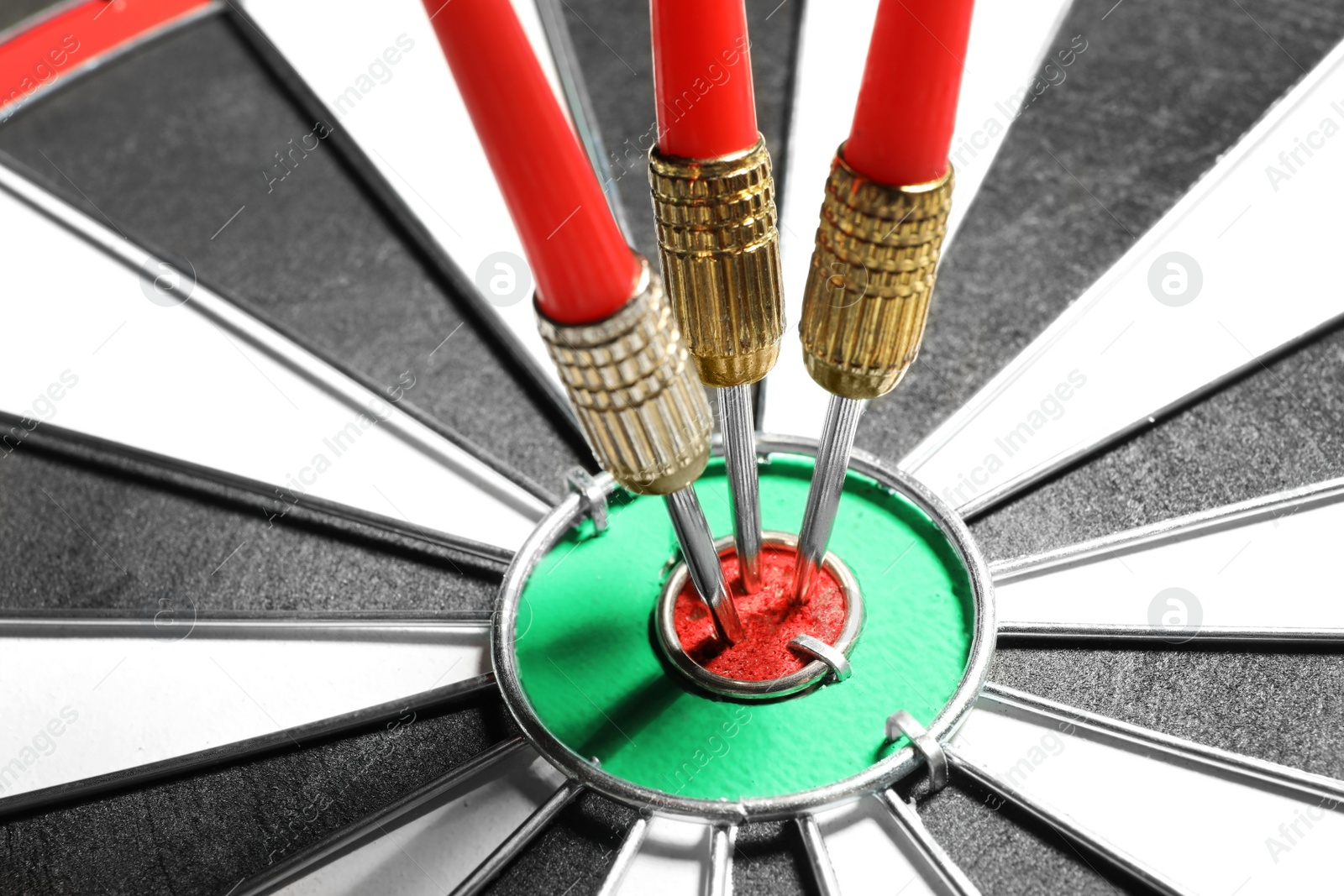 Photo of Dart board with red arrows hitting target, closeup