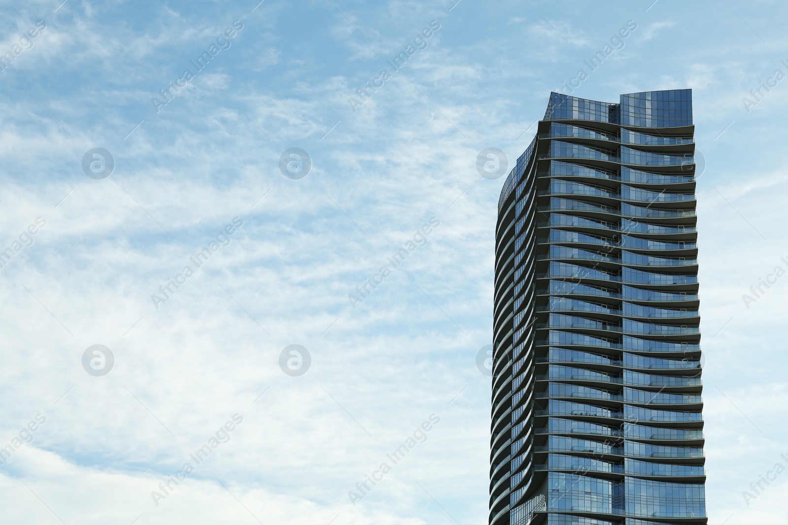 Photo of Exterior of modern building against cloudy sky, space for text