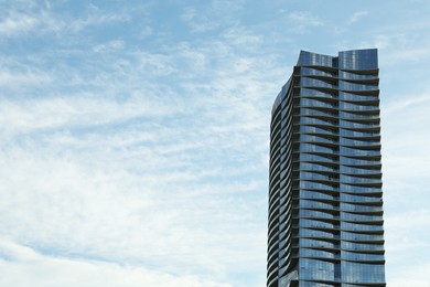 Photo of Exterior of modern building against cloudy sky, space for text