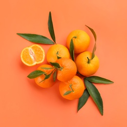 Photo of Fresh tangerines with green leaves on coral background, flat lay
