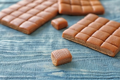 Photo of Delicious caramel candies on wooden background