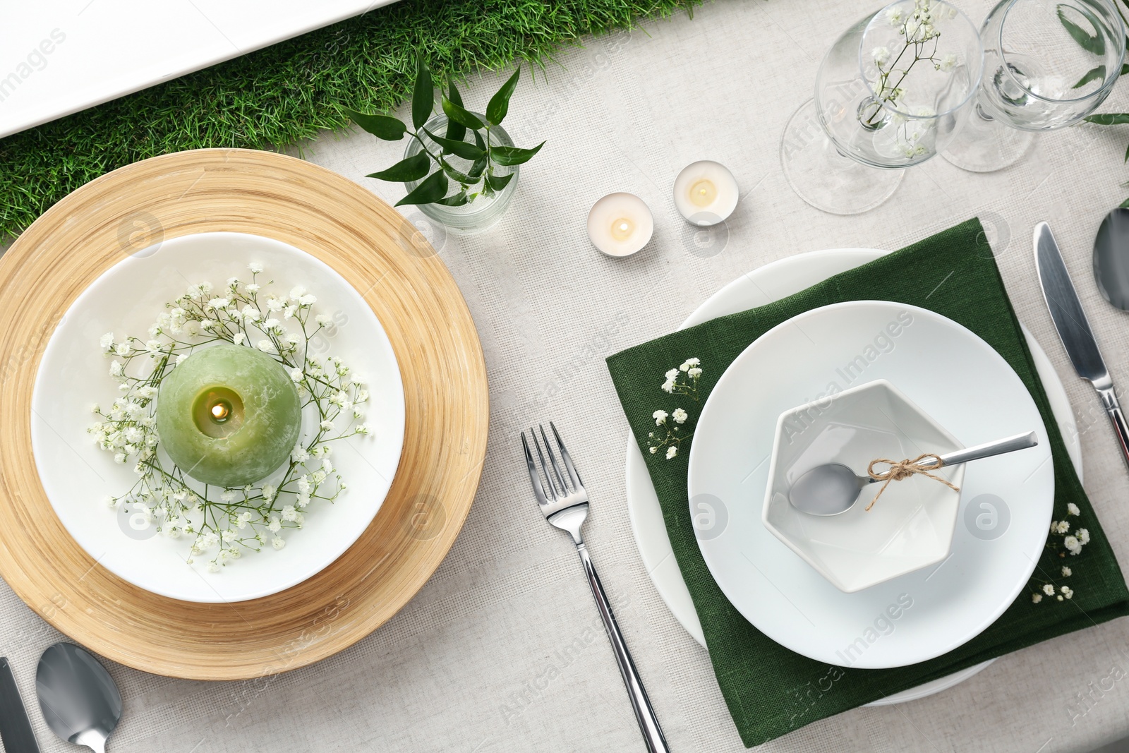 Photo of Elegant table setting with green plants on light cloth, flat lay