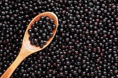 Photo of Spoon and many elderberries (Sambucus) as background, top view