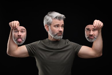 Image of Mature man holding masks with his face showing different emotions on black background. Balanced personality
