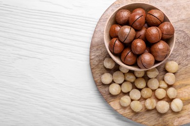 Delicious Macadamia nuts on white wooden table, top view. Space for text