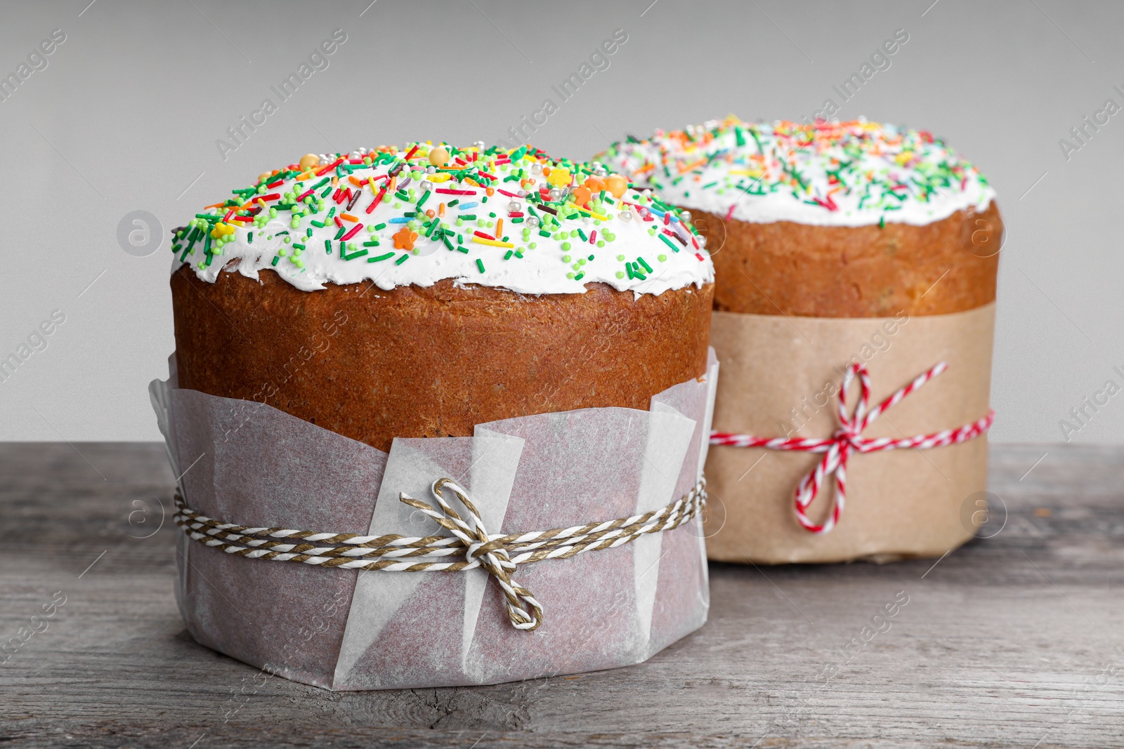 Photo of Traditional Easter cakes with sprinkles on wooden table, closeup