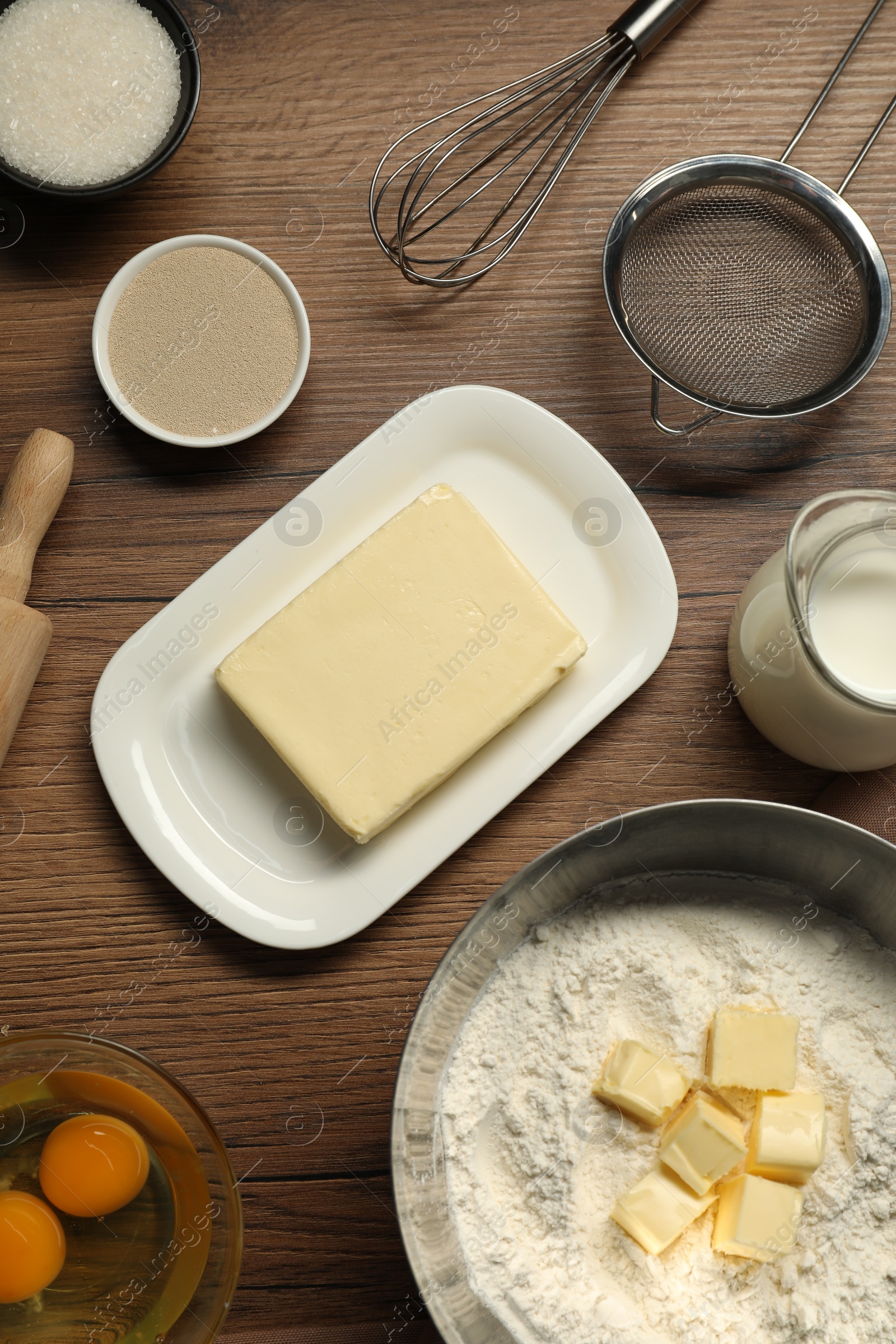 Photo of Flat lay composition with fresh butter among other products on wooden table