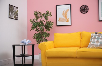 Photo of Modern living room interior with comfortable yellow sofa near color wall