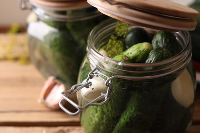 Photo of Jar with cucumbers, garlic and dill on wooden table, closeup. Pickling recipe