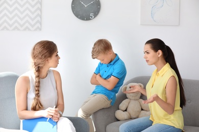 Young mother and her son visiting child psychologist in office