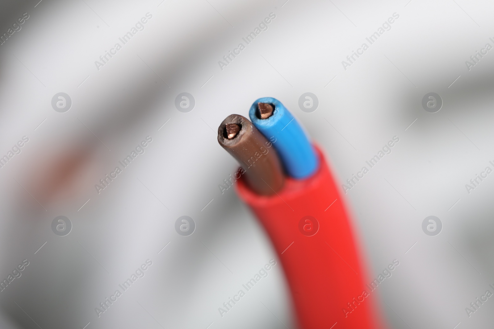 Photo of Colorful electrical wire on blurred background, closeup. Space for text