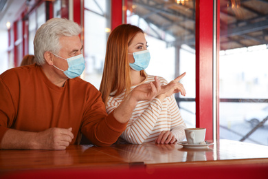 People with medical masks in cafe. Virus protection