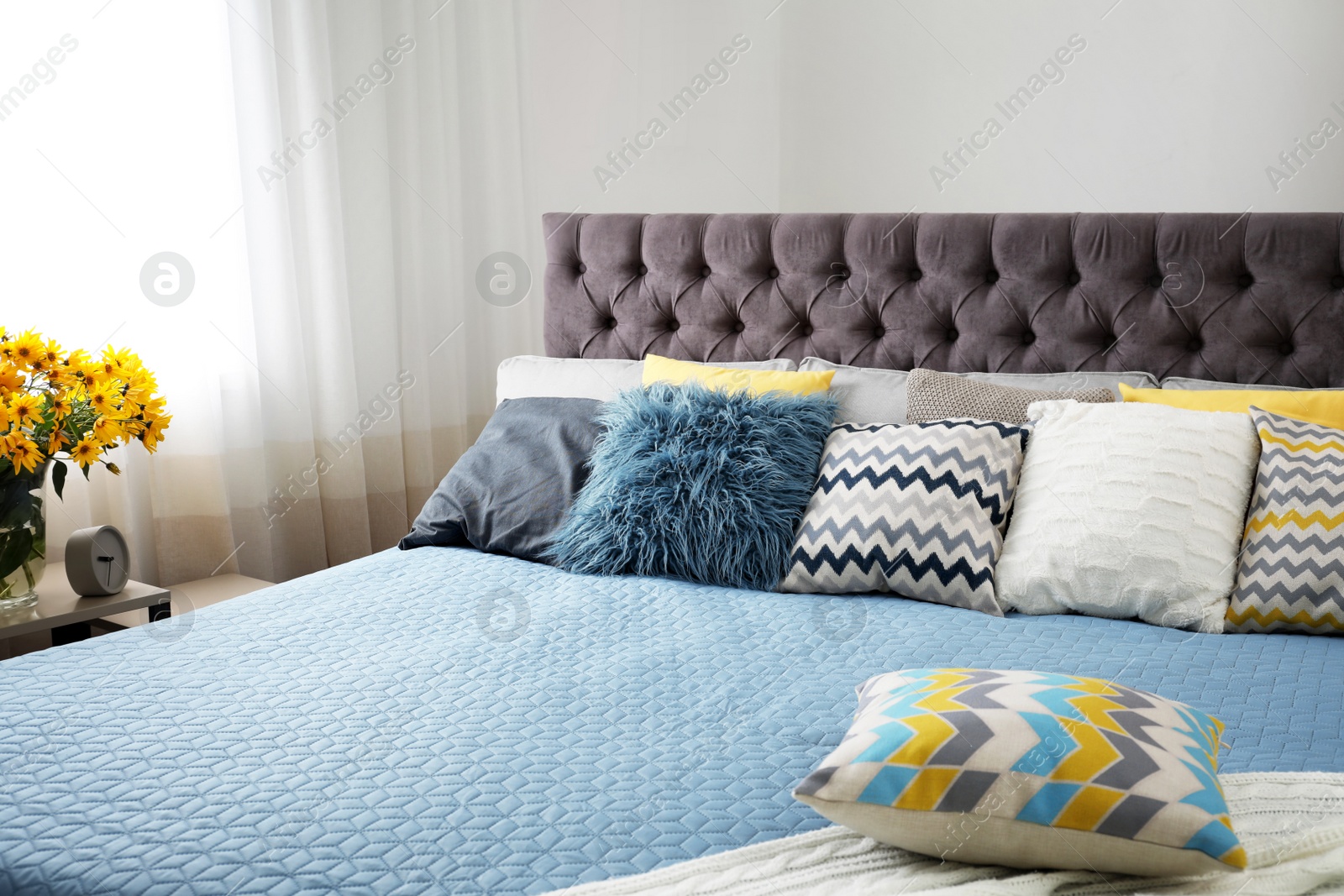 Photo of Different pillows on bed in room. Idea for interior decor