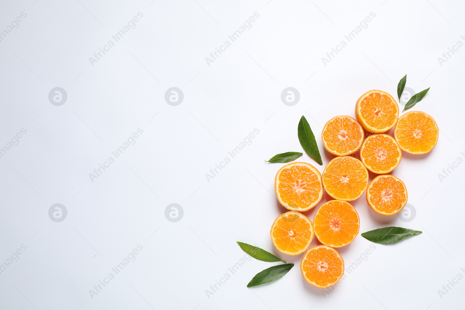 Photo of Composition with halves of fresh ripe tangerines and space for text on white background, flat lay. Citrus fruit