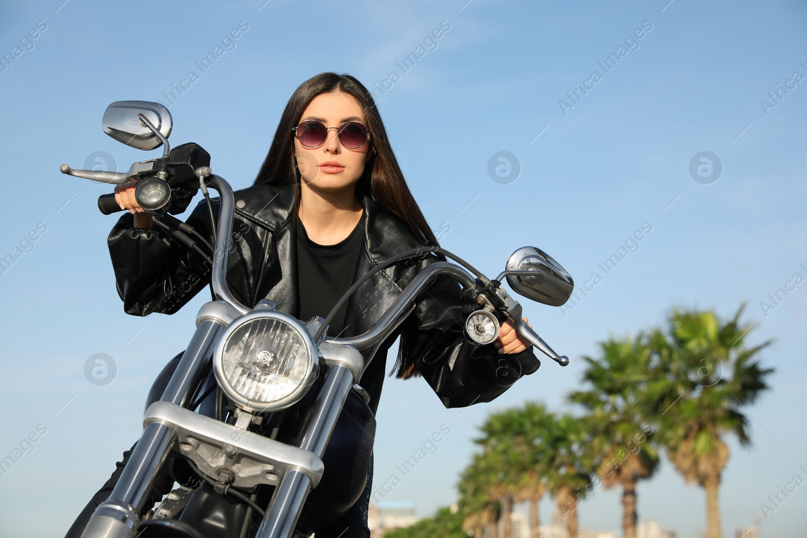 Photo of Beautiful young woman riding motorcycle on sunny day