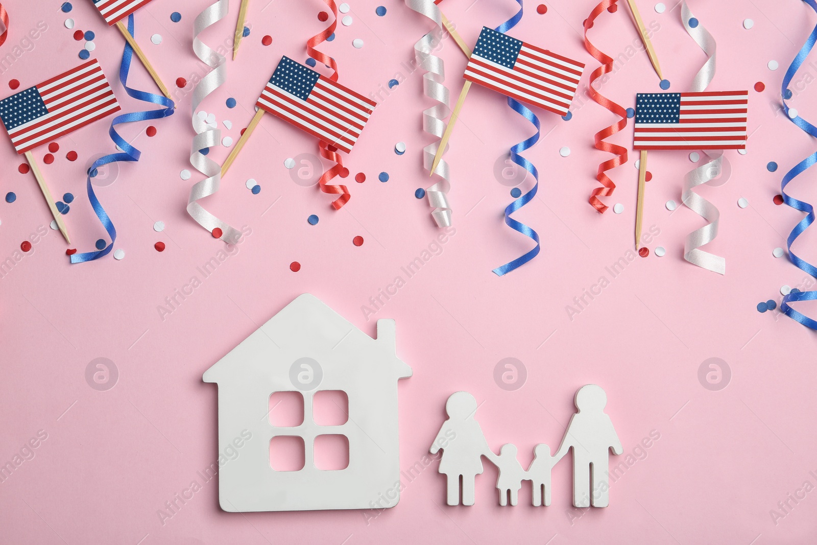 Photo of Flat lay composition with USA flags, house and family figures on color background. Happy Independence Day
