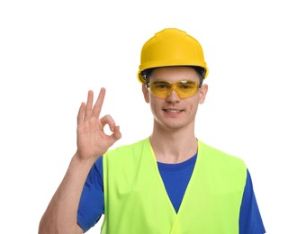 Young man wearing safety equipment and showing ok gesture on white background