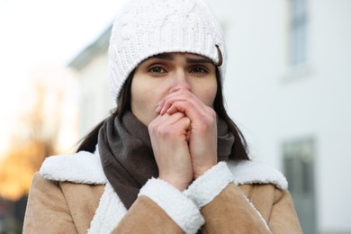 Photo of Sick young woman coughing outdoors. Cold symptom