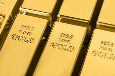 Photo of Many shiny gold bars as background, closeup