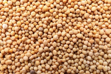 Photo of Heap of mustard seeds as background, closeup