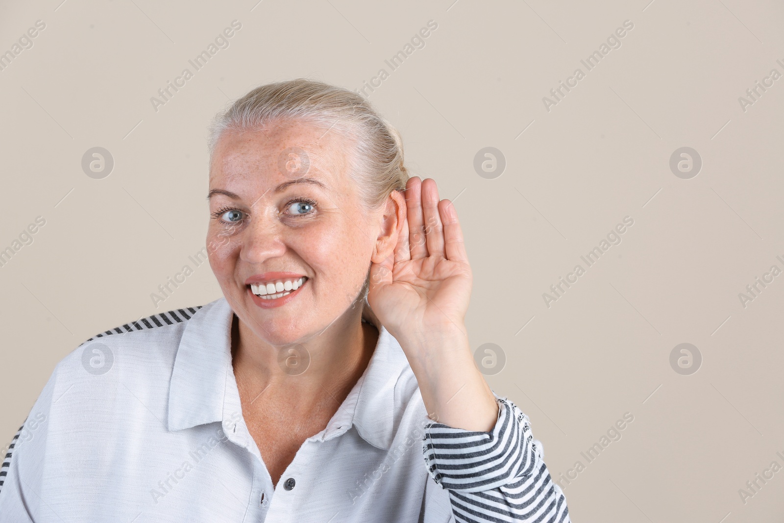 Photo of Mature woman with hearing problem on light background