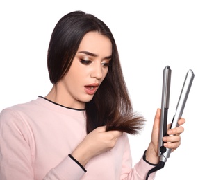 Emotional woman with hair iron on white background