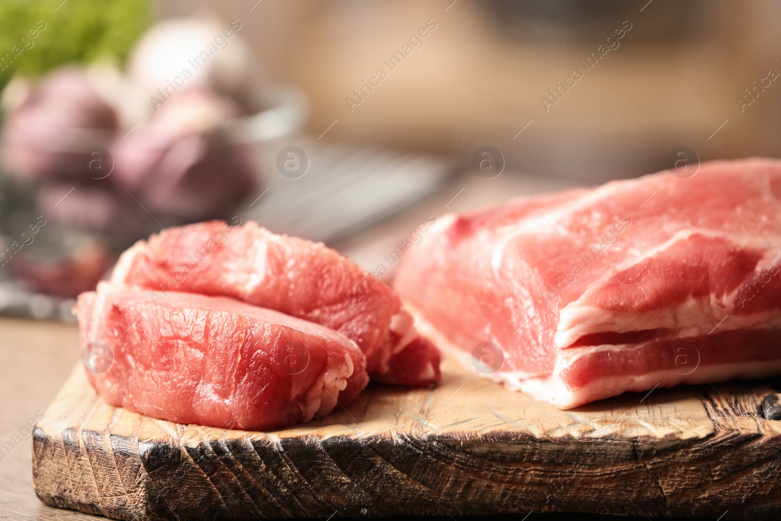 Photo of Fresh raw meat on wooden board in kitchen, closeup