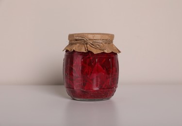 Photo of Jar of tasty pickled beets on white background