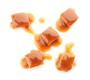 Delicious candies with caramel sauce on white background