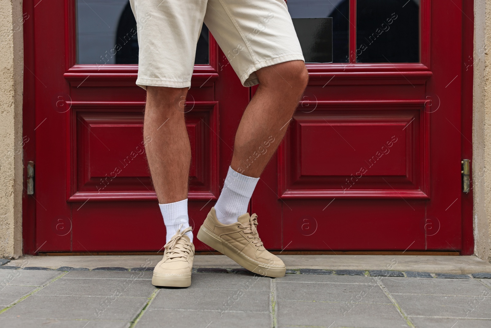 Photo of Man wearing pair of stylish sneakers outdoors, closeup