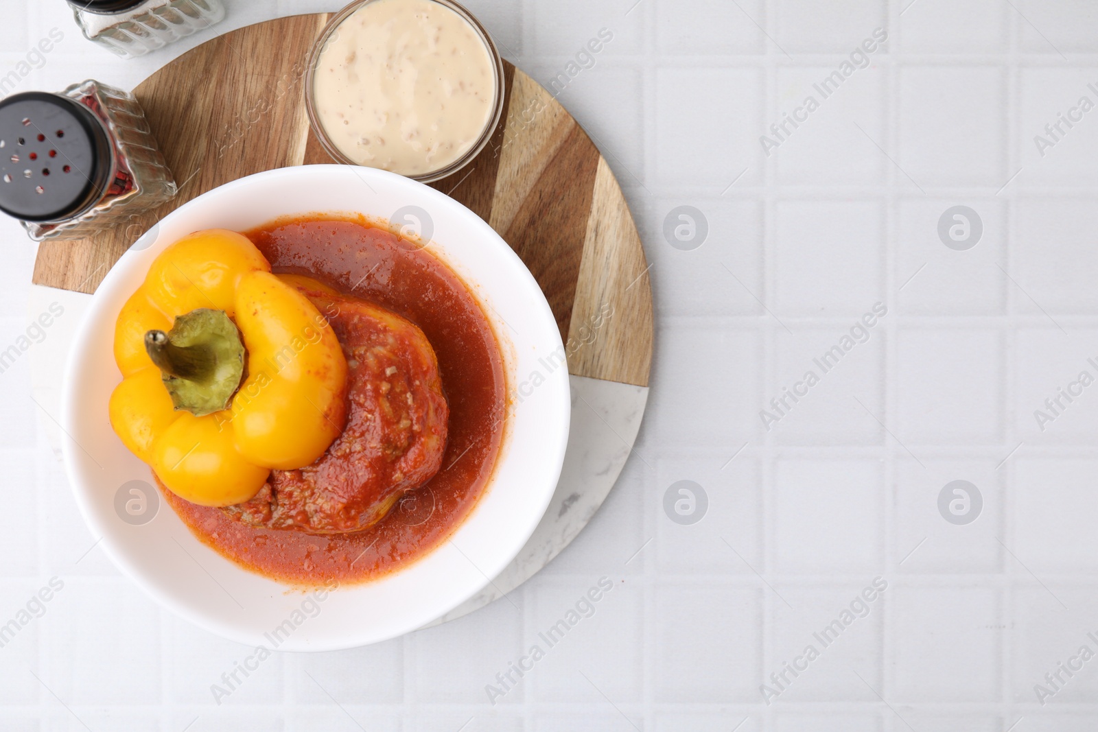 Photo of Delicious stuffed bell pepper served on white tiled table, flat lay. Space for text